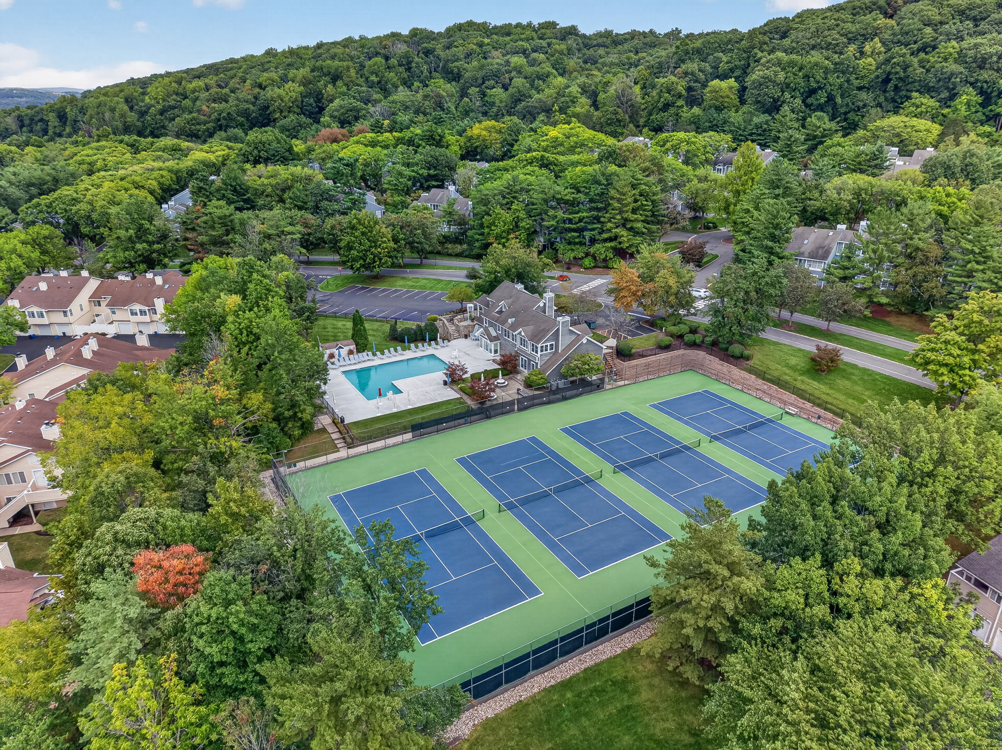 COMMUNITY PICTURE Residents of The Hills enjoy an array of amenities including a pool, tennis courts, clubhouse and fitness center, all within a beautifully maintained community setting.