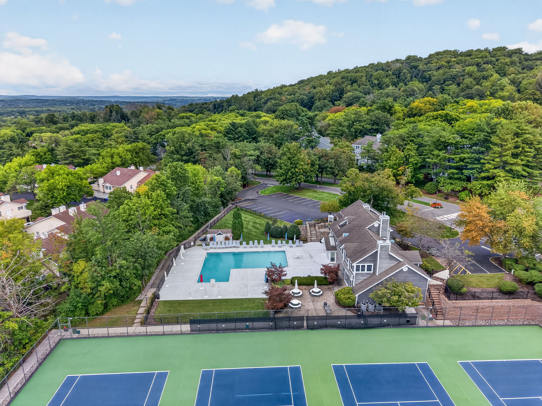 COMMUNITY PICTURE Residents of The Hills enjoy an array of amenities including a pool, tennis courts, clubhouse and fitness center, all within a beautifully maintained community setting.