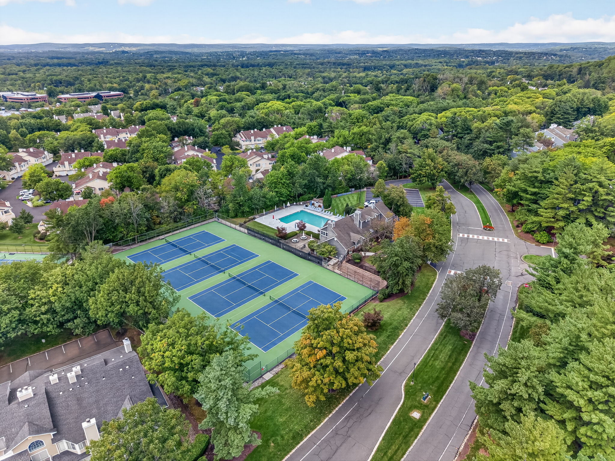 COMMUNITY PICTURE Residents of The Hills enjoy an array of amenities including a pool, tennis courts, clubhouse and fitness center, all within a beautifully maintained community setting.