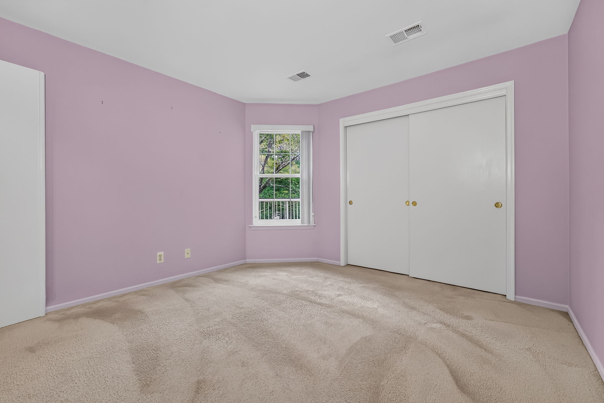 1st FLOOR BEDROOM Double doors open to the first-floor bedroom with a double slider door closet and wall-to-wall carpet..