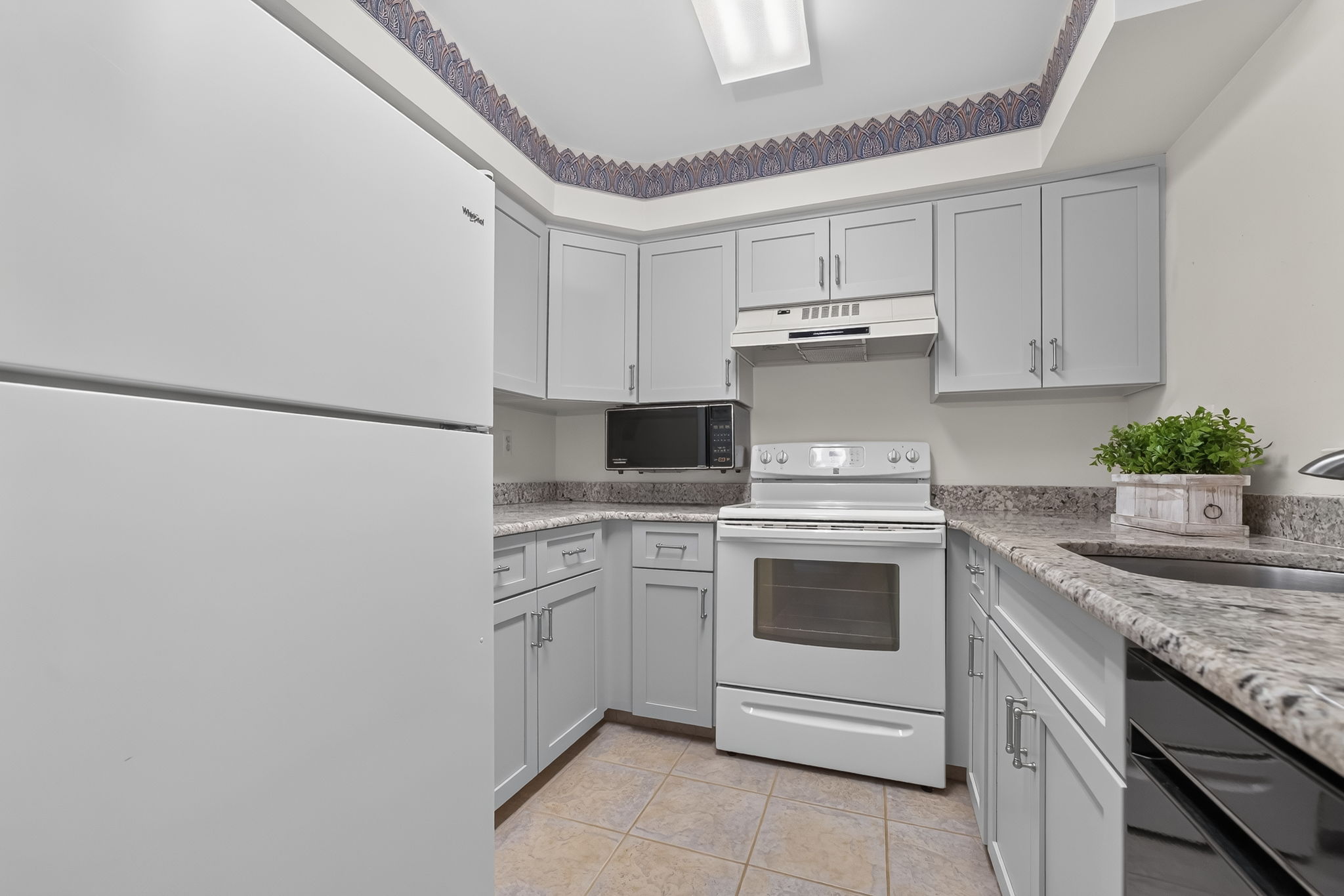 KITCHEN The tastefully renovated kitchen features Shaker cabinetry, granite countertops and ceramic tile flooring.