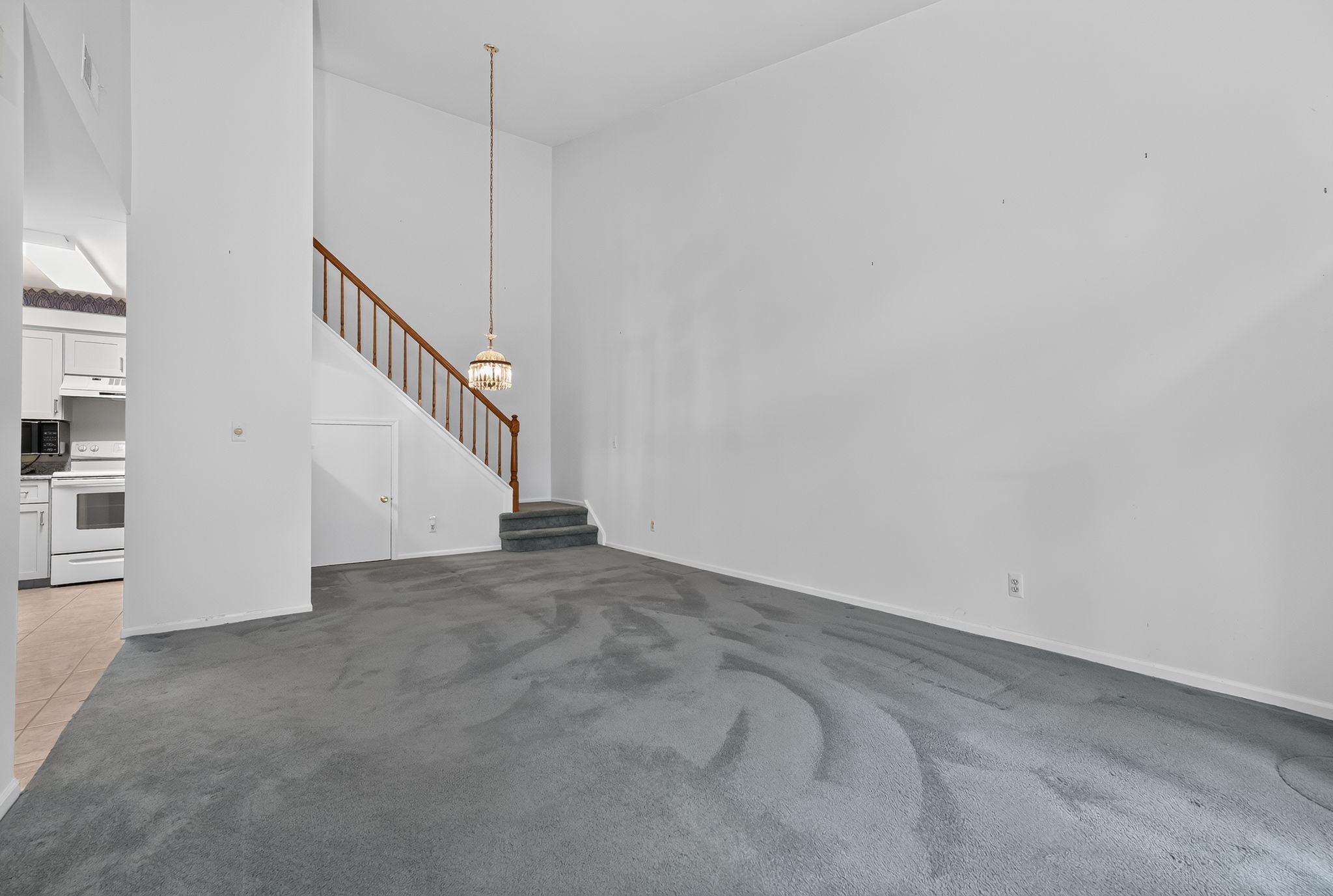 LIVING/DINING ROOM The open-concept main level feels bright and spacious, enhanced by a vaulted ceiling and glass slider leading to a private composite deck—an inviting spot for morning coffee and relaxation. Deck access to a convenient storage closet.