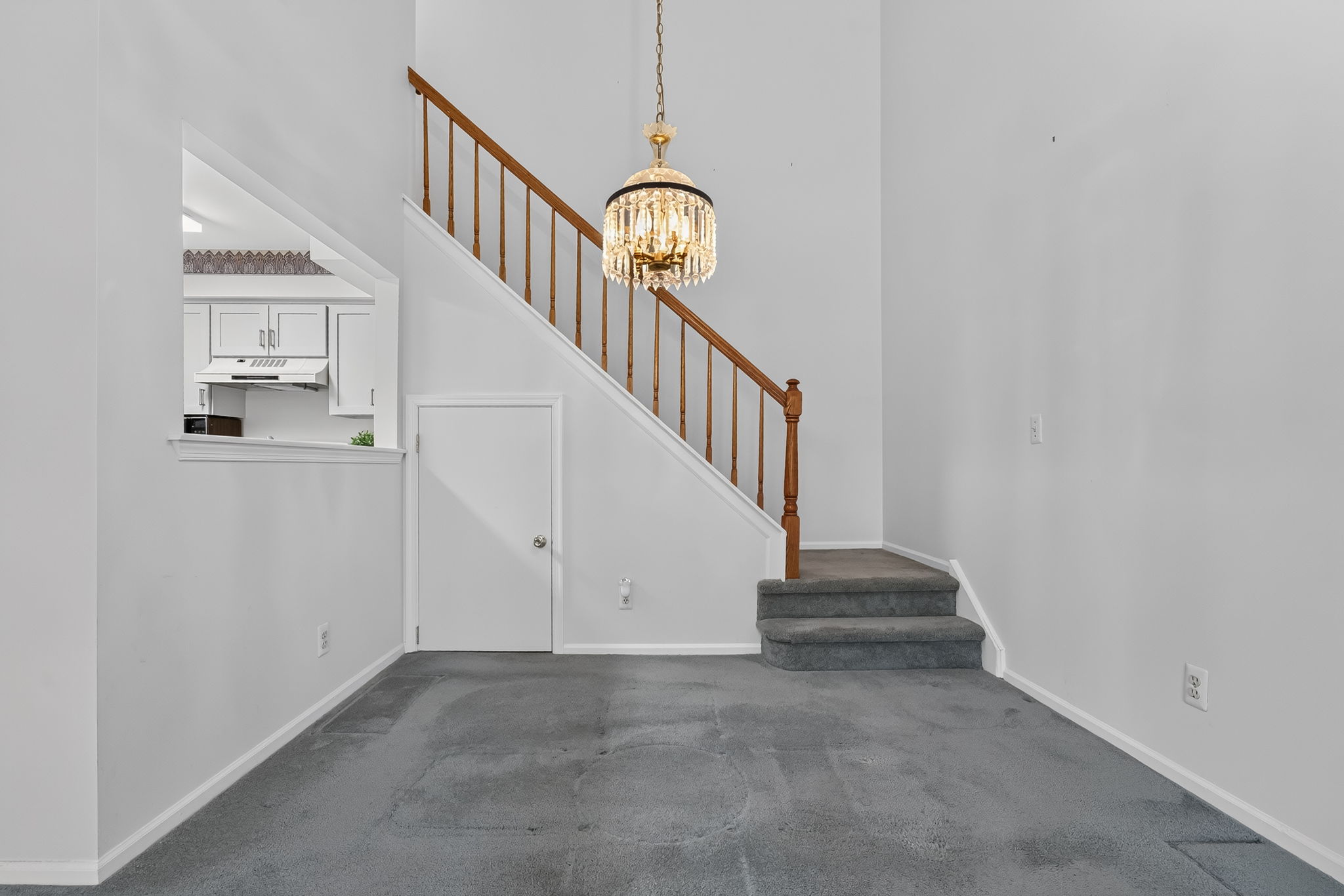 LIVING/DINING ROOM The open-concept main level feels bright and spacious, enhanced by a vaulted ceiling and glass slider leading to a private composite deck—an inviting spot for morning coffee and relaxation. Deck access to a convenient storage closet