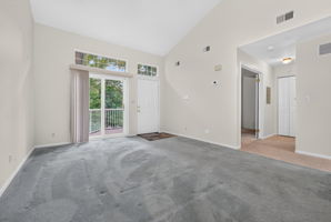 LIVING/DINING ROOM The open-concept main level feels bright and spacious, enhanced by a vaulted ceiling and glass slider leading to a private composite deck—an inviting spot for morning coffee and relaxation. Deck access to a convenient storage closet.