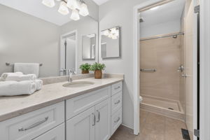 EN SUITE BATH Designed with a spa-like feel, the bath features a Shaker vanity with quartz countertop, high gloss marble-like acrylic walk-in shower and ceramic tile flooring.