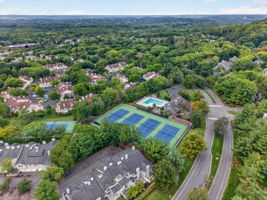 COMMUNITY PICTURE Residents of The Hills enjoy an array of amenities including a pool, tennis courts, clubhouse and fitness center, all within a beautifully maintained community setting.