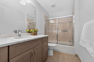 1st FLOOR BATH An updated full bath features a Shaker vanity with quartz countertop, tub-shower with ceramic tile surround and tile flooring.