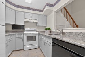 KITCHEN The tastefully renovated kitchen features Shaker cabinetry, granite countertops and ceramic tile flooring.