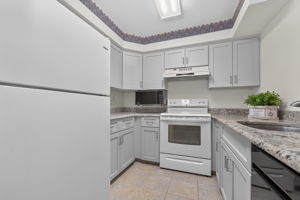 KITCHEN The tastefully renovated kitchen features Shaker cabinetry, granite countertops and ceramic tile flooring.