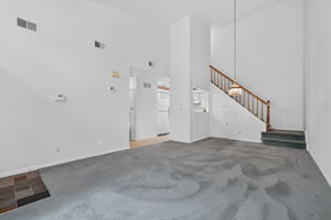 LIVING/DINING ROOM The open-concept main level feels bright and spacious, enhanced by a vaulted ceiling and glass slider leading to a private composite deck—an inviting spot for morning coffee and relaxation. Deck access to a convenient storage closet