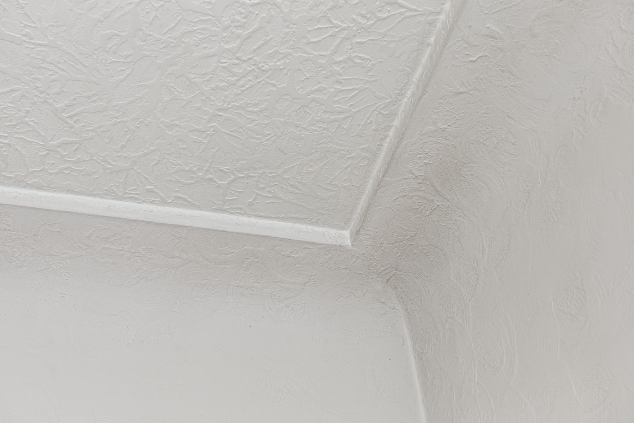 Close-up of the coved ceiling and textured plasterwork.
