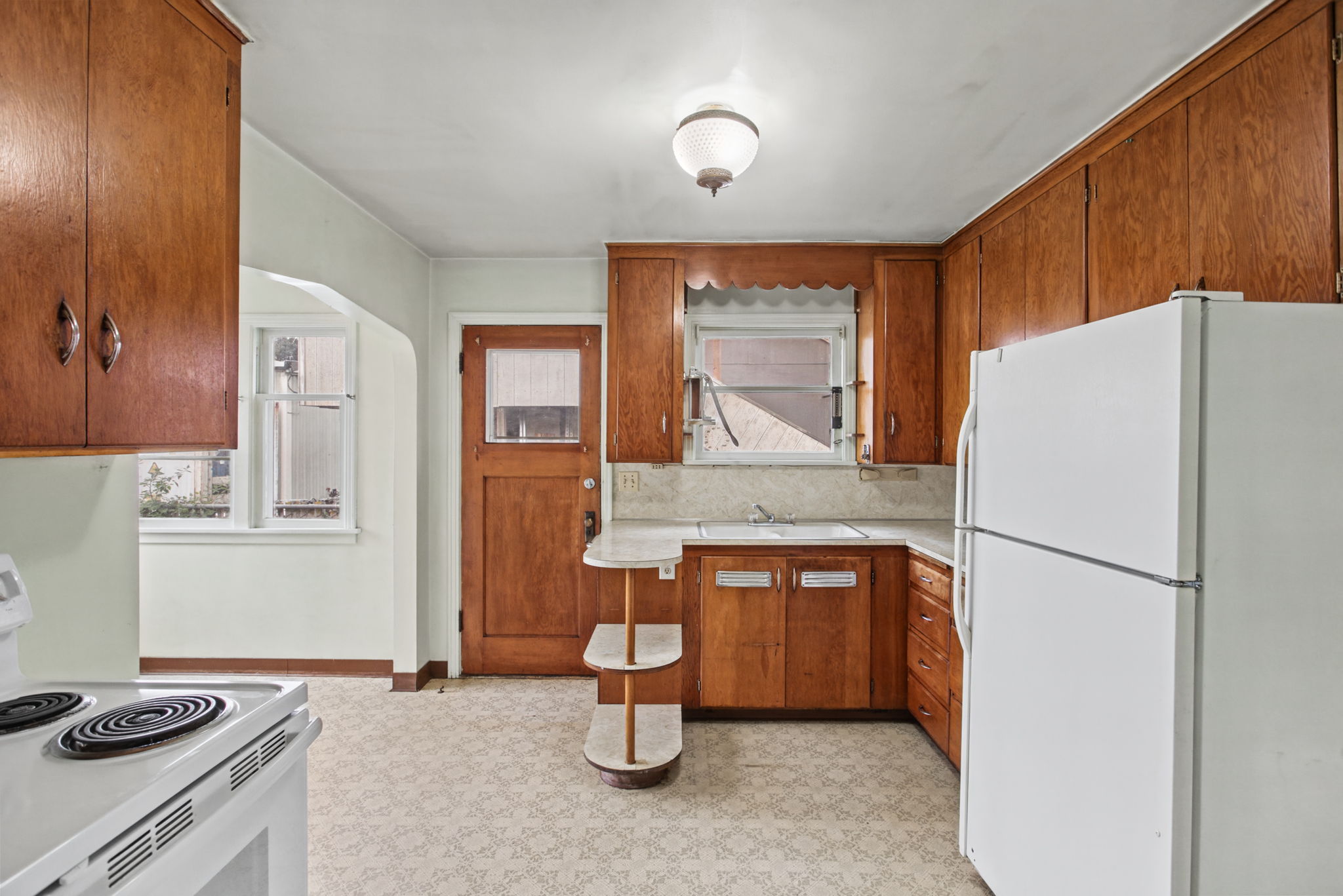 Dated but functional kitchen with substantial wood cabinetry and a distinctive curved counter.