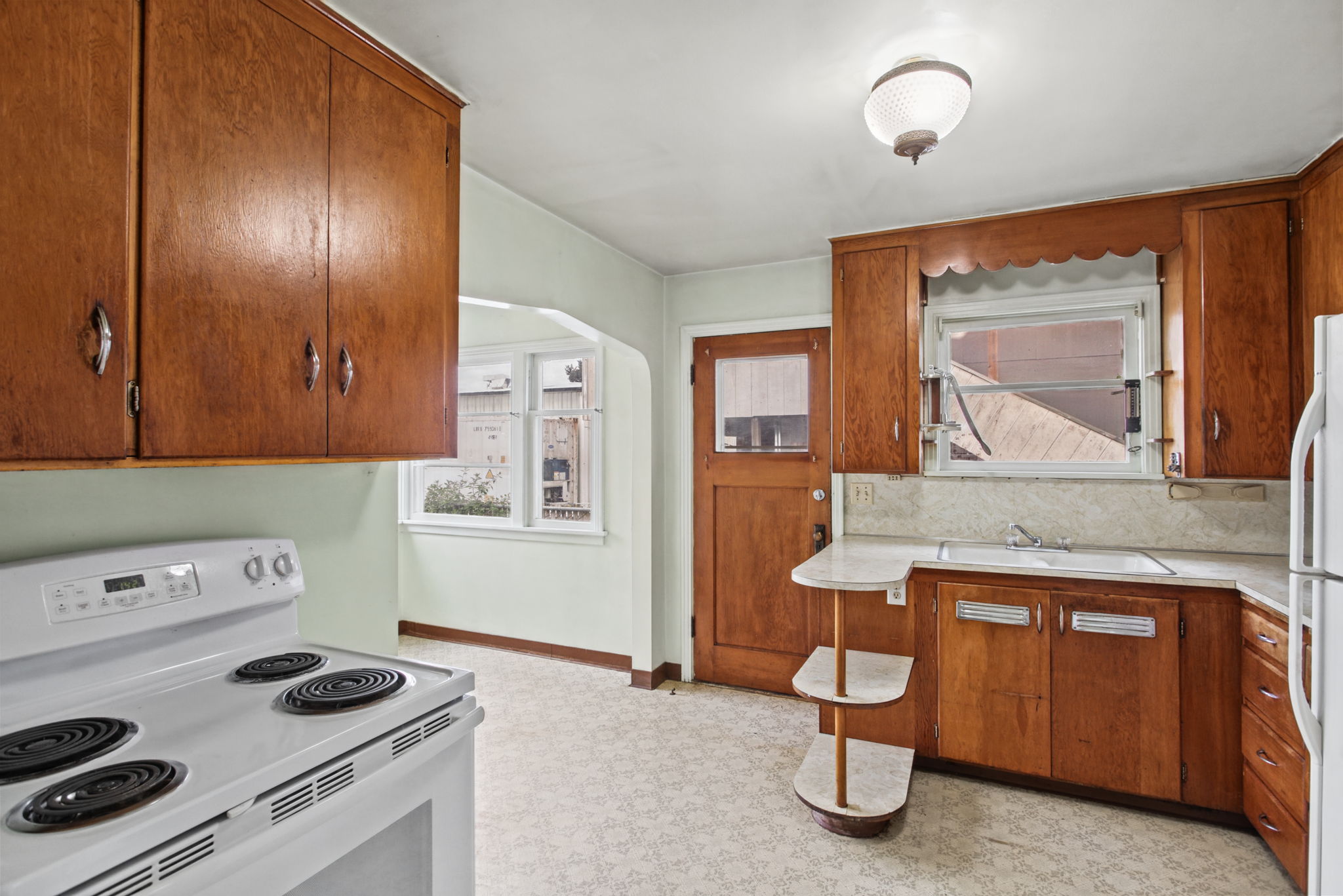 Another kitchen angle showing the cooking area, sink wall and adjacent eating space.