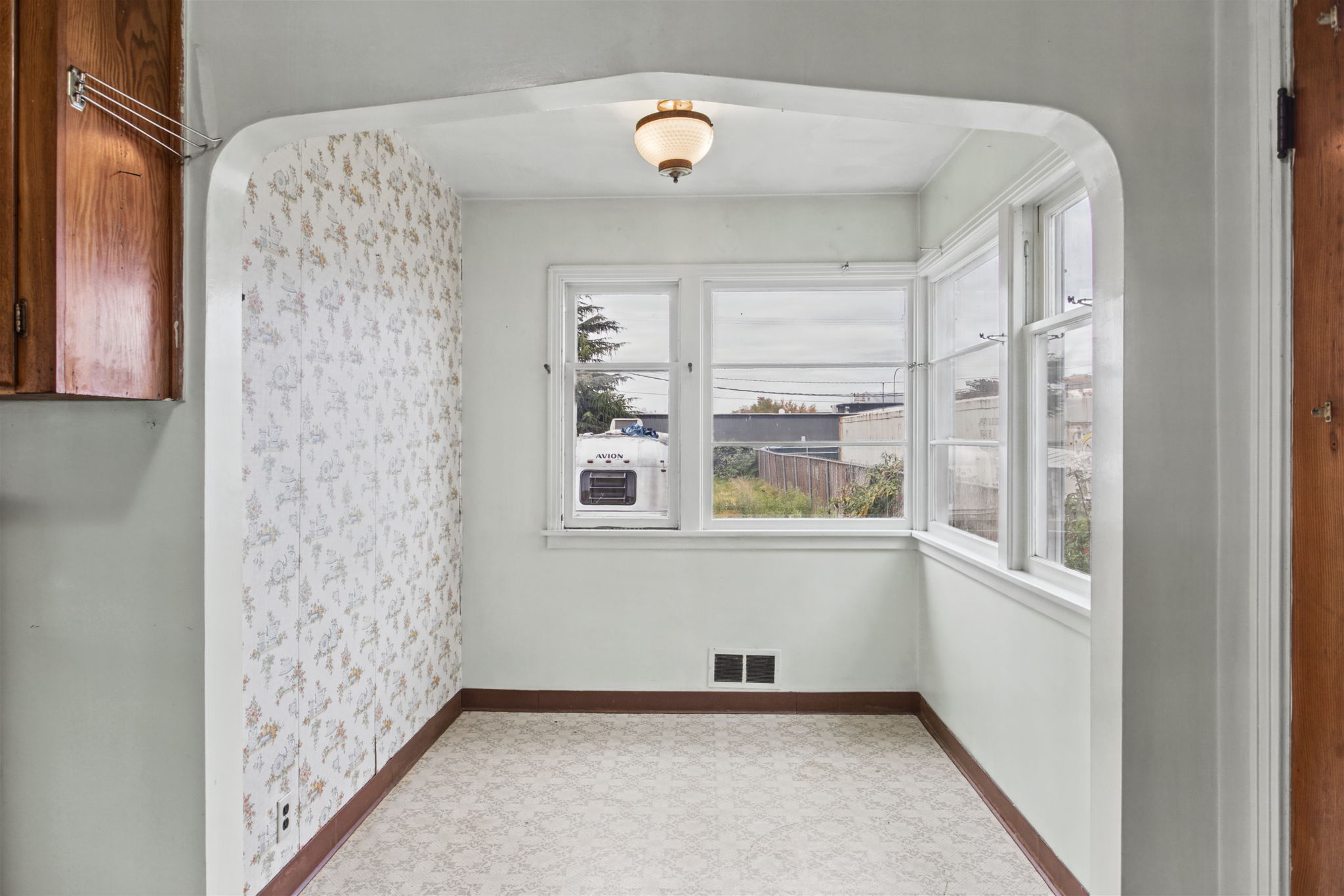 Wide arched opening connects the kitchen to the breakfast nook.