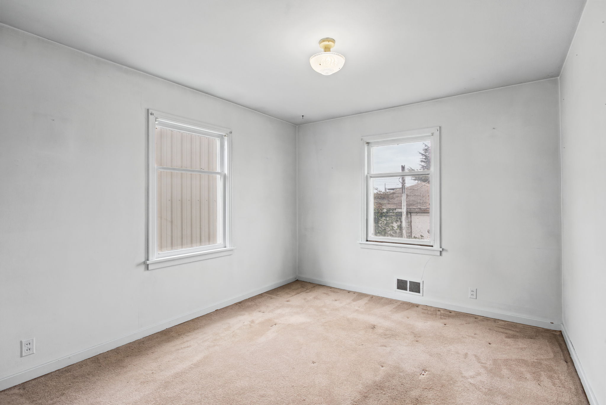 Second main-floor bedroom with windows on two sides.
