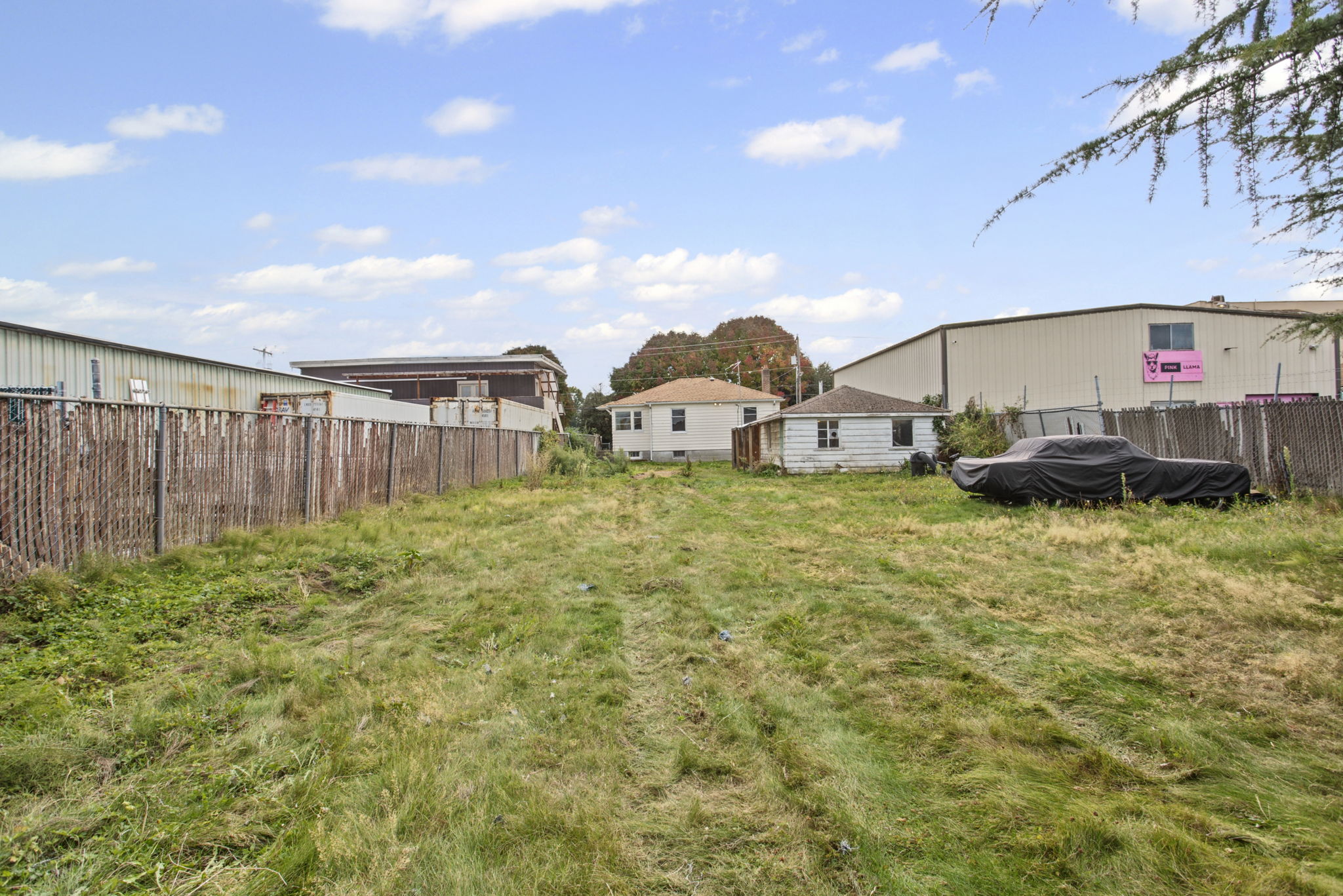 Reverse yard view toward the house and detached garage, showing the parcel’s substantial depth.