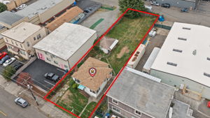 Oblique aerial highlights the home, detached garage and substantial depth of the street-to-alley lot.