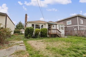 Wide front and side-yard view; the parcel extends through to rear alley access.