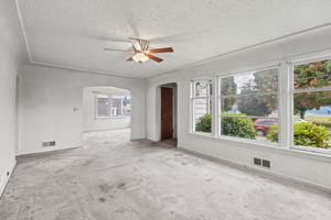 Arched openings connect the living room to the formal dining room and adjacent hall.