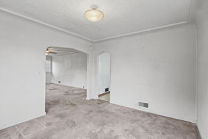 Reverse view highlights the room’s coved ceiling and arched openings.