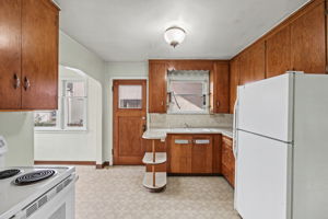 Dated but functional kitchen with substantial wood cabinetry and a distinctive curved counter.