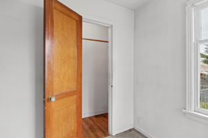 Paneled wood door and bedroom closet; hardwood flooring is visible inside the closet.