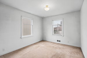Second main-floor bedroom with windows on two sides.