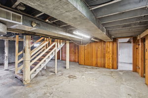 Largely unfinished basement with good ceiling height, open project/storage space and exterior access.