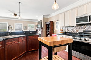 The kitchen island stays and provides convenient space to serve or prepare food