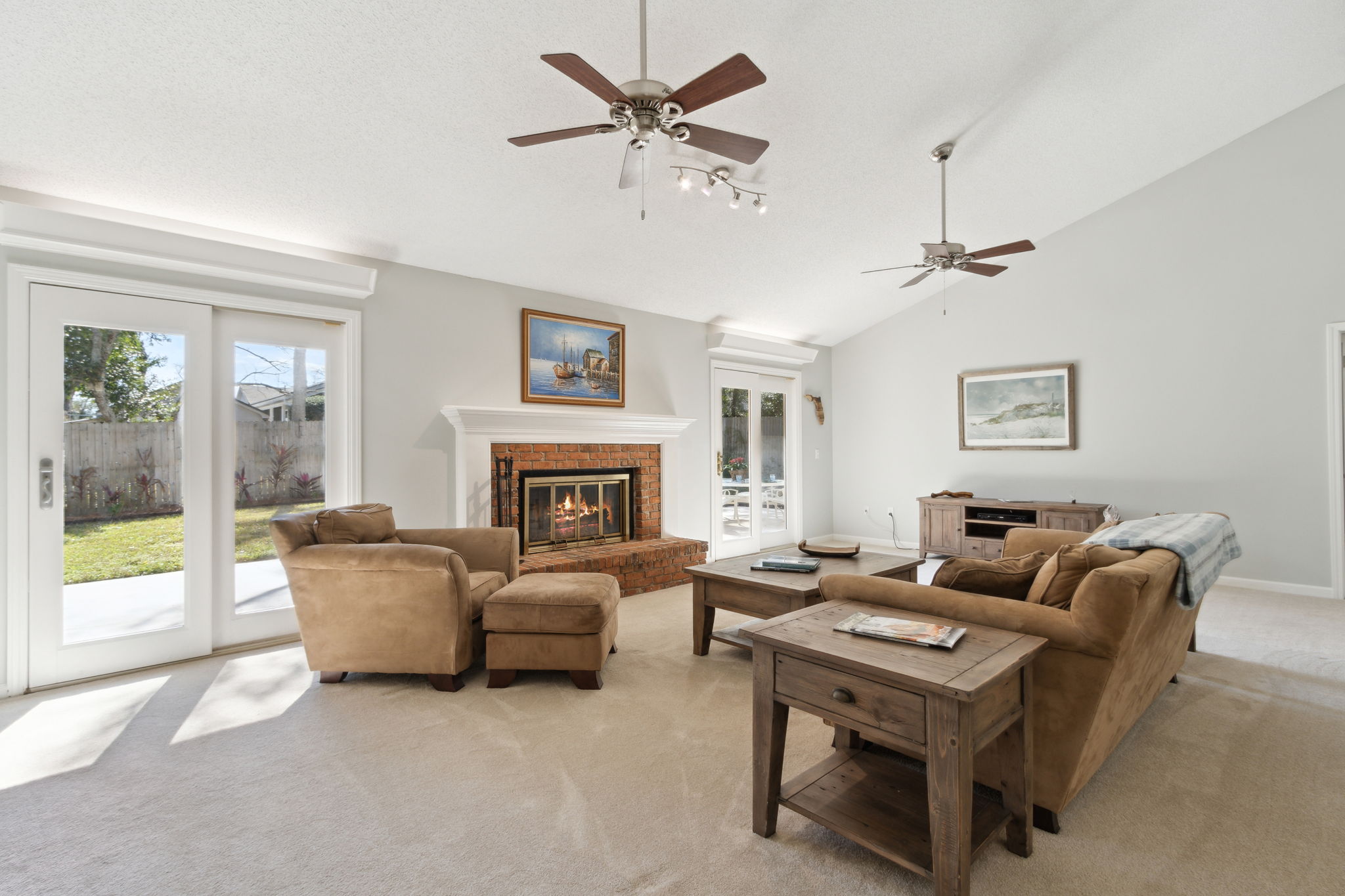 Great Room with Vaulted Ceiling, Wood burning fireplace and sliding doors to the patio and fenced backyard