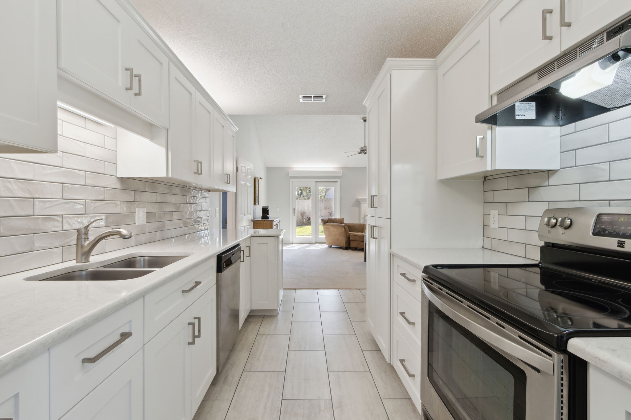 Kitchen with Quartz countertops, Subway Tile Backspash and Porcelain Tile Floors.