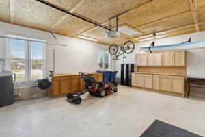 2 Car Garage with built in Cabinets  and a bright area for a workshop- Toys are hanging from the ceiling