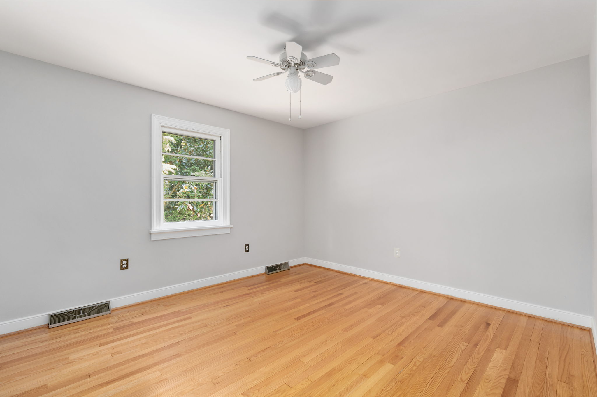 Secondary bedroom with wood floors and ceiling fan!