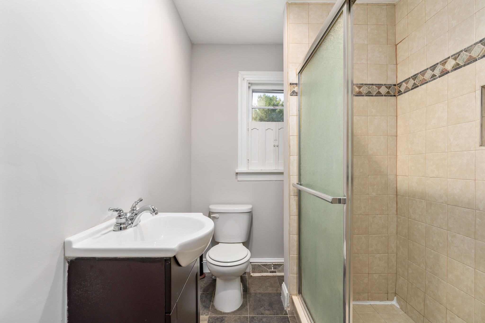 Bathroom offers ceramic tile shower with multiple shower heads!