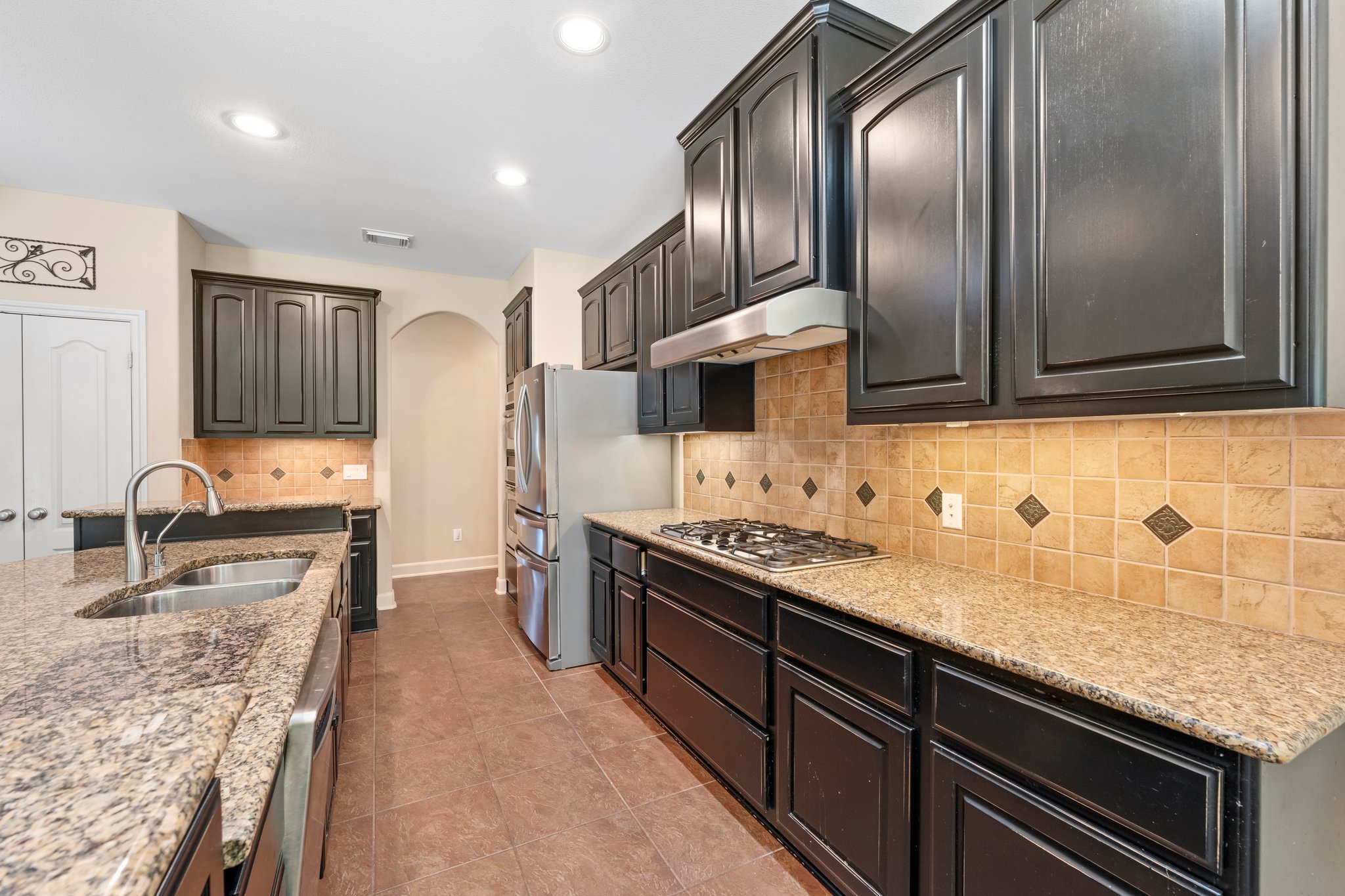 Kitchen has double door pantry, no-touch faucet, 5 burner gas cooktop.