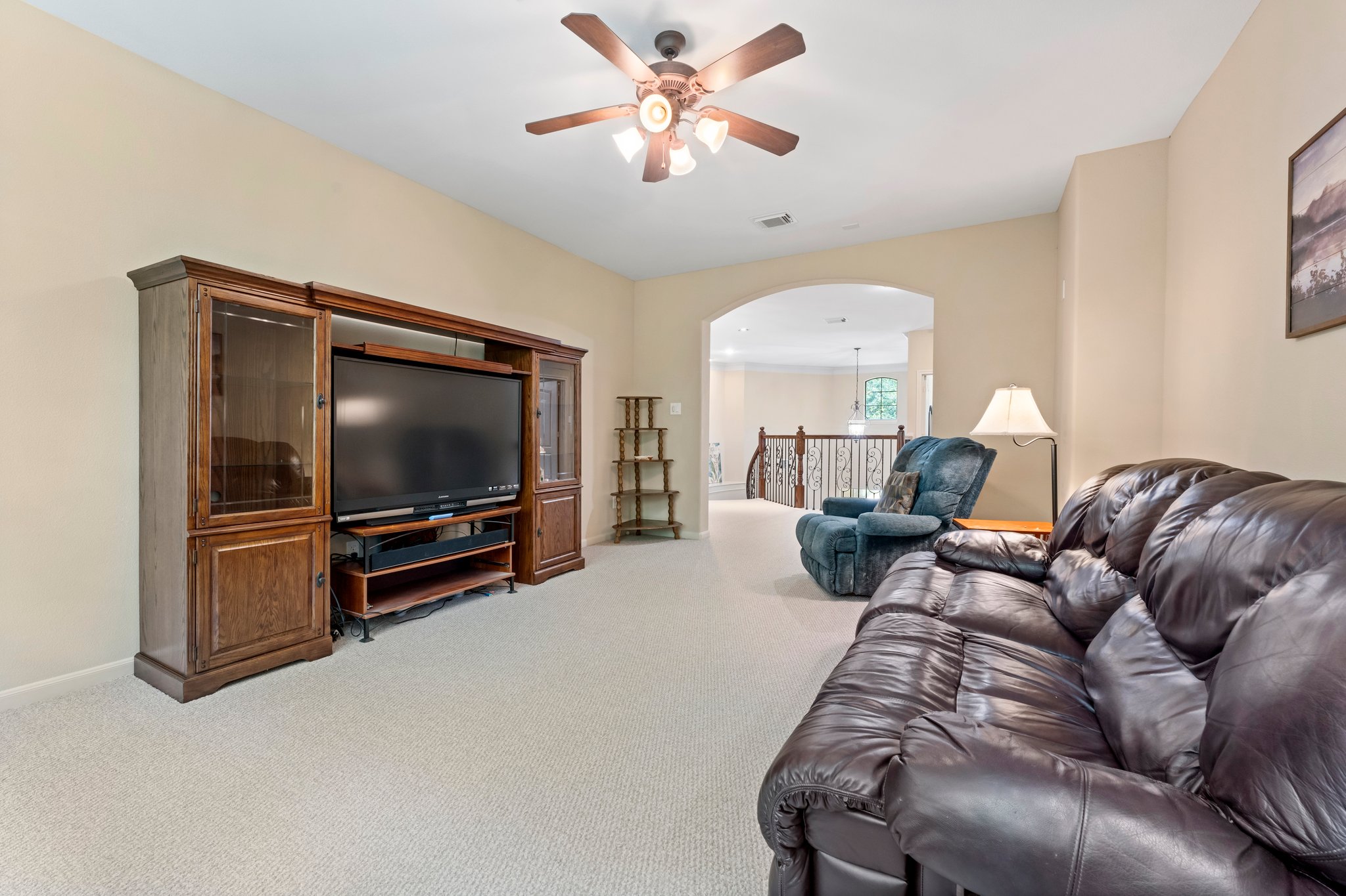 Another view of Upstairs game/family room with ceiling fan and arch entry.