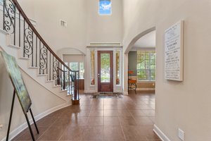 Additional view of the front entry with decorative glass door and arched entries to study and dining room.