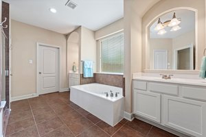 Primary bathroom features double sinks, large framed mirrors, and tile floors.