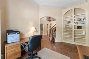 Study/office features wall of built ins and arched entry.