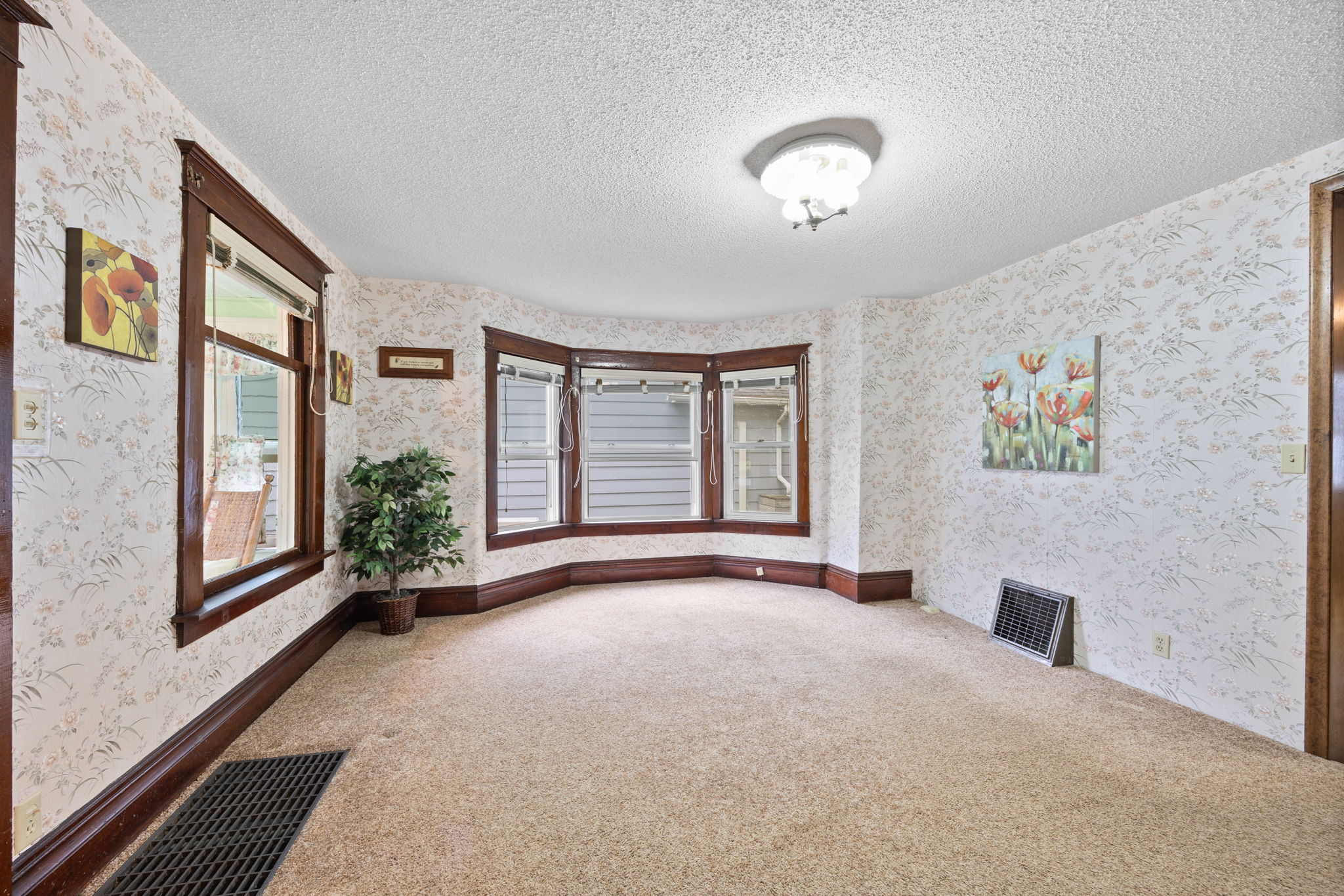 This room features oversized base molding, elaborate trim detail around doors and windows, and a floor to ceiling bay window. The home also has the original glass window looking out onto the porch.An addition off the back of the home allows room for a spacious eat-in-kitchen with plenty of storage!