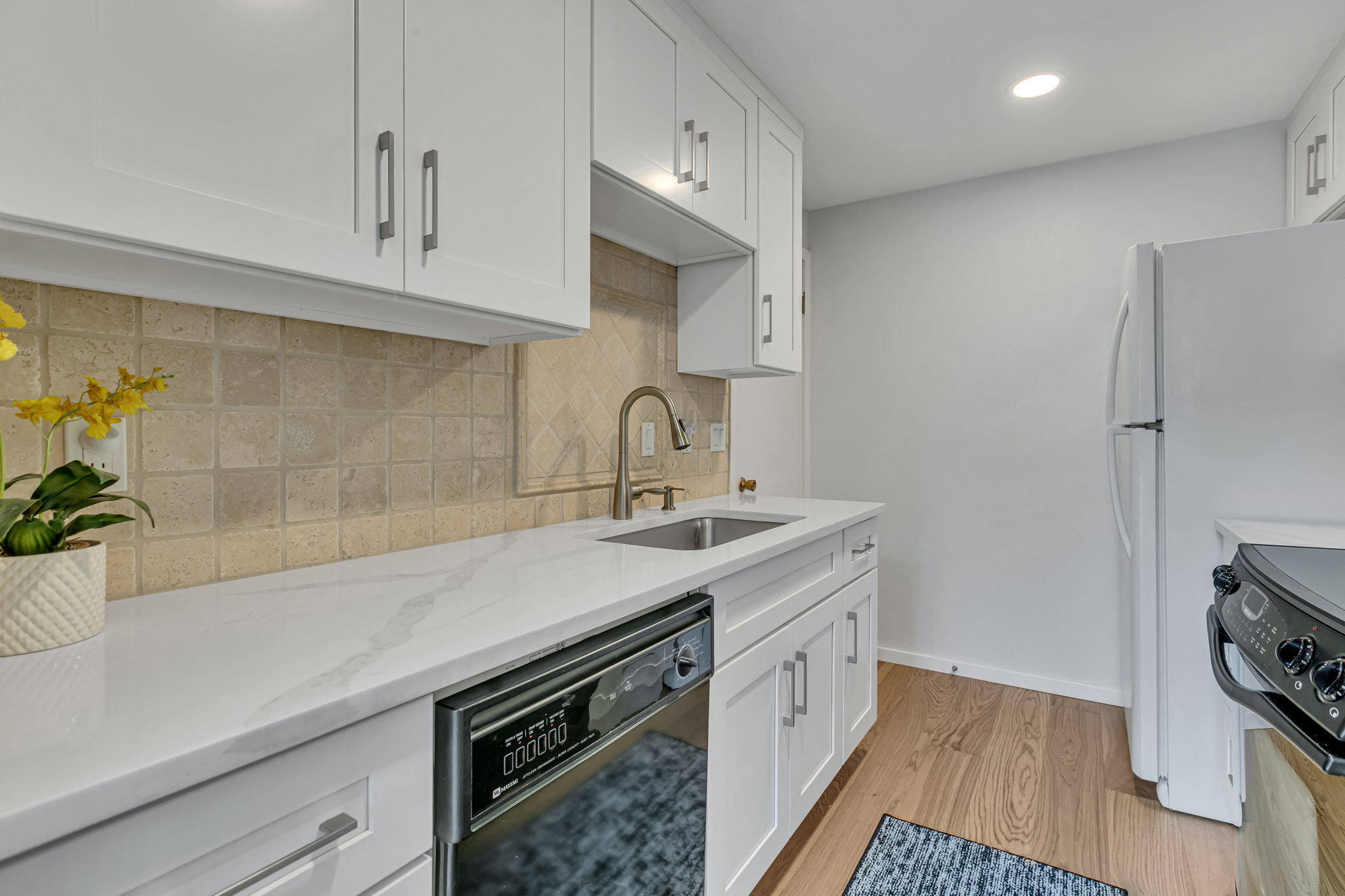 Updated kitchen with quartz countertops and tile backsplash.