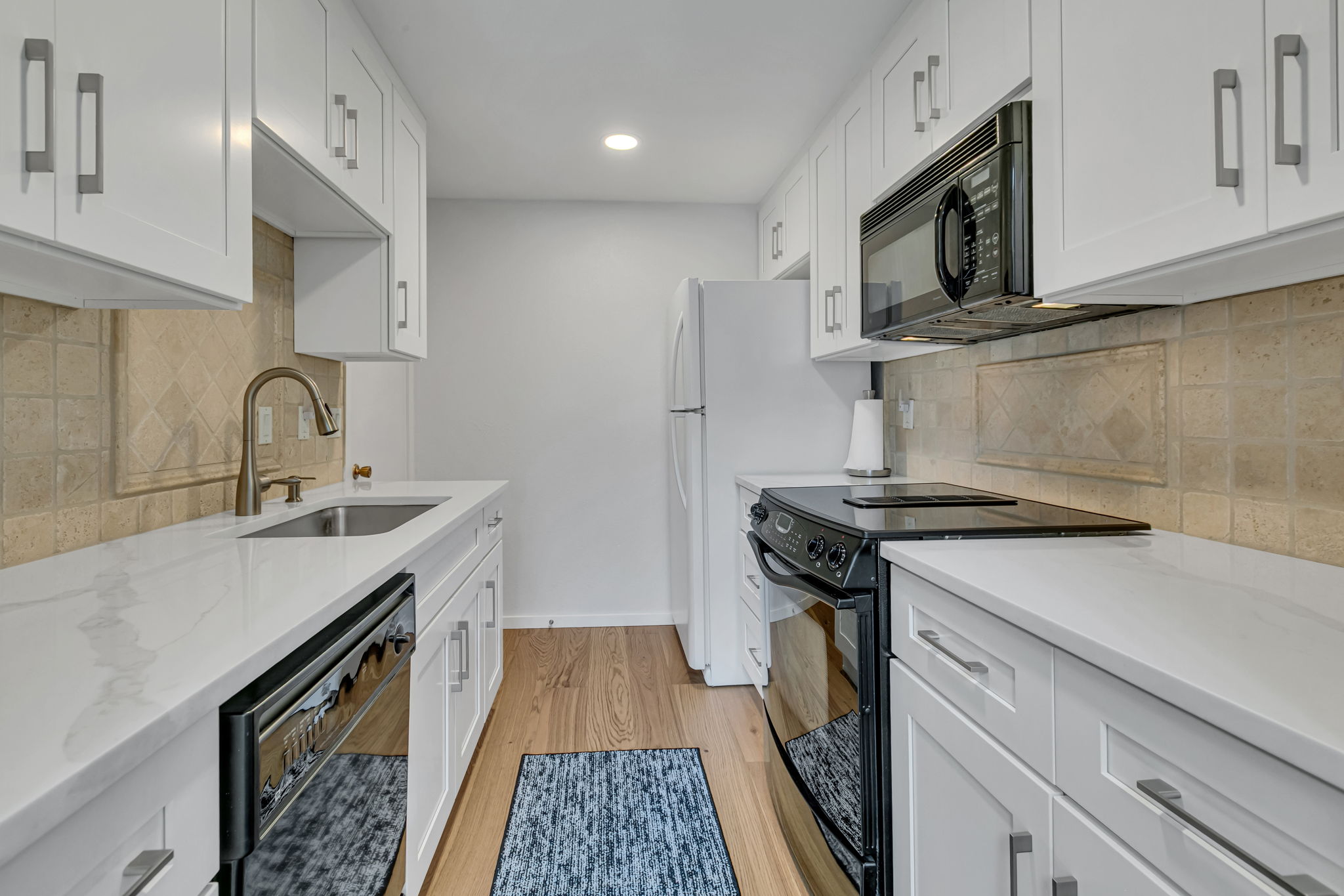 Galley kitchen with white Shaker-style cabinetry and generous counter space.