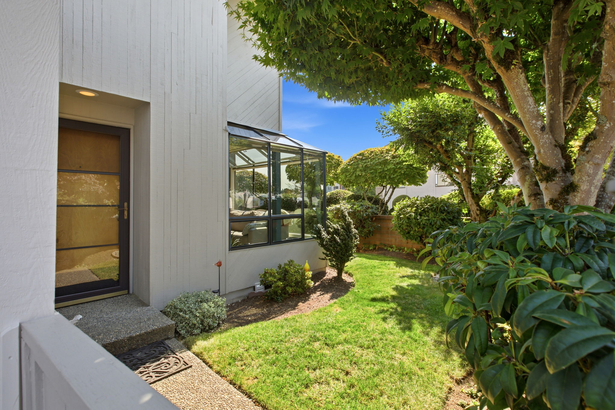 A garden gate opens to the landscaped side yard.