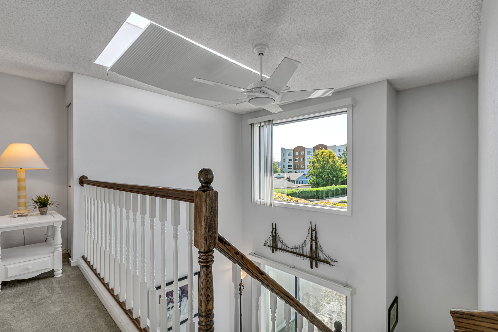 Open loft overlooks the main level beneath an oversized skylight with an adjustable shade.