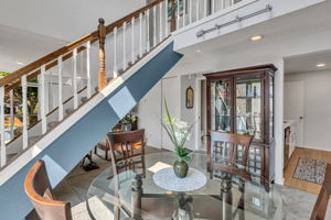 Open spindle staircase keeps the view flowing between the dining and living areas.
