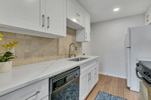Updated kitchen with quartz countertops and tile backsplash.