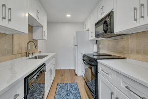 Galley kitchen with white Shaker-style cabinetry and generous counter space.