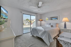 Large primary bedroom with a ceiling fan and private balcony.