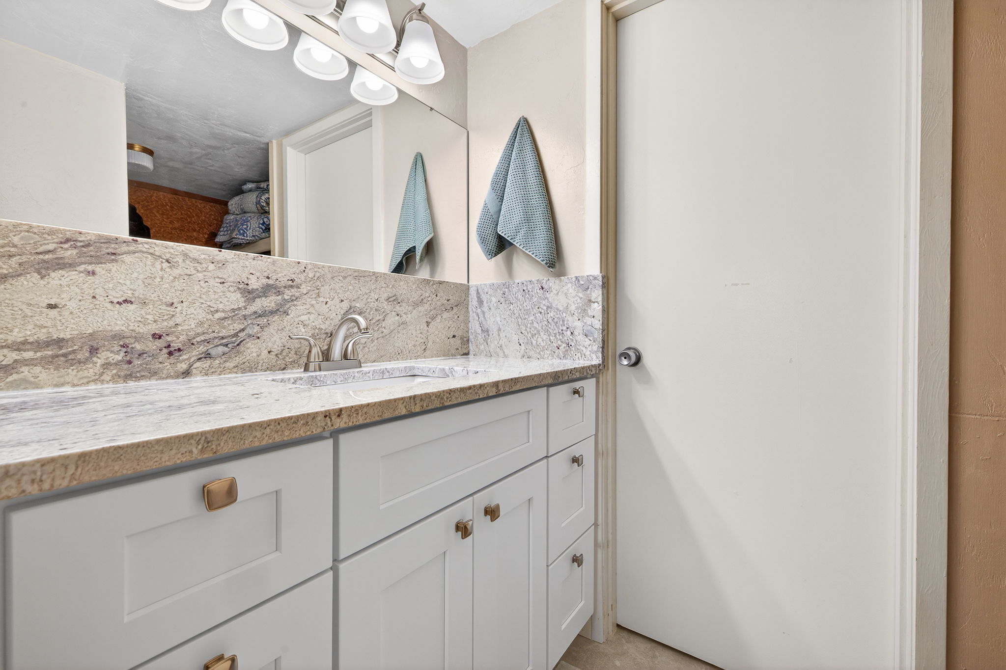 New granite topped vanity, mirror, lightiing backsplace