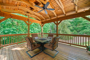 Step onto the Covered Deck overlooking backyard